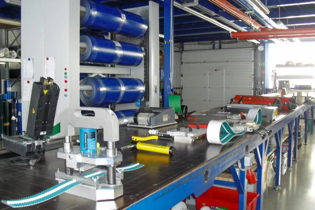 Werkhalle mit Maschinerie und Materialrollen